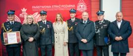 Na zdjęciu widoczni są od prawej: Wice Starosta Powiatu Ostrowieckiego, Wiceprezes Zarządu Oddziału Wojewódzkiego ZOSP RP, Prezydent Ostrowca Świętokrzyskiego, Świętokrzyski Komendant Wojewódzki PSP, Starosta Ostrowiecki, p.o. Komendant Powiatowy PSP w Ostrowcu Św., Radna Sejmiku Województwa Świętokrzyskiego, Zastępca Dowódcy JRG nr 1 w Ostrowcu Św.