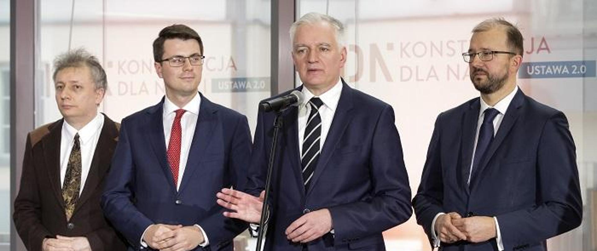 Ministrowie stoją na tle okna