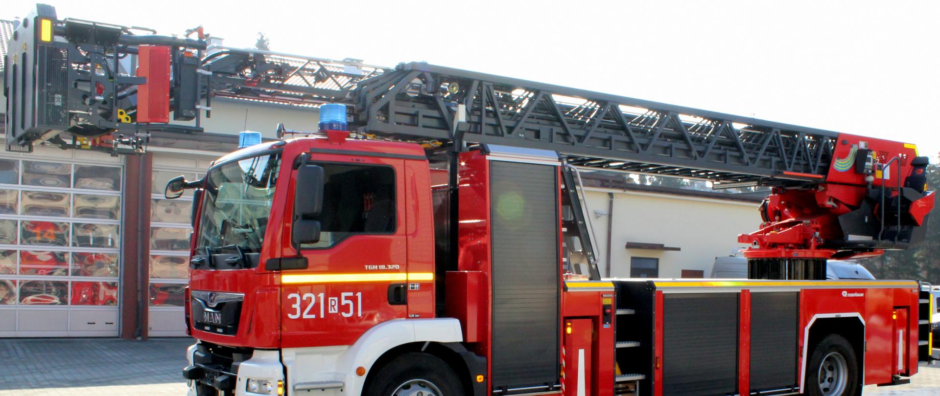 Zdjęcie przedstawia widok pojazdu specjalnego - drabiny marki Rosenbauer model L42A-XS ustawionej na placu wewnętrznym Komendy Miejskiej Państwowej Straży Pożarnej w Rzeszowie