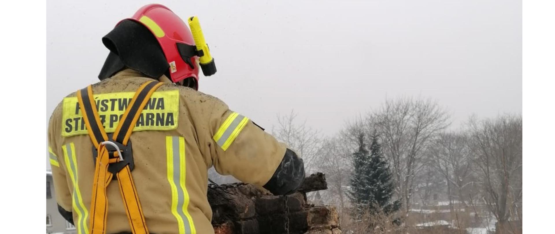 Strażak stojący obok komina
