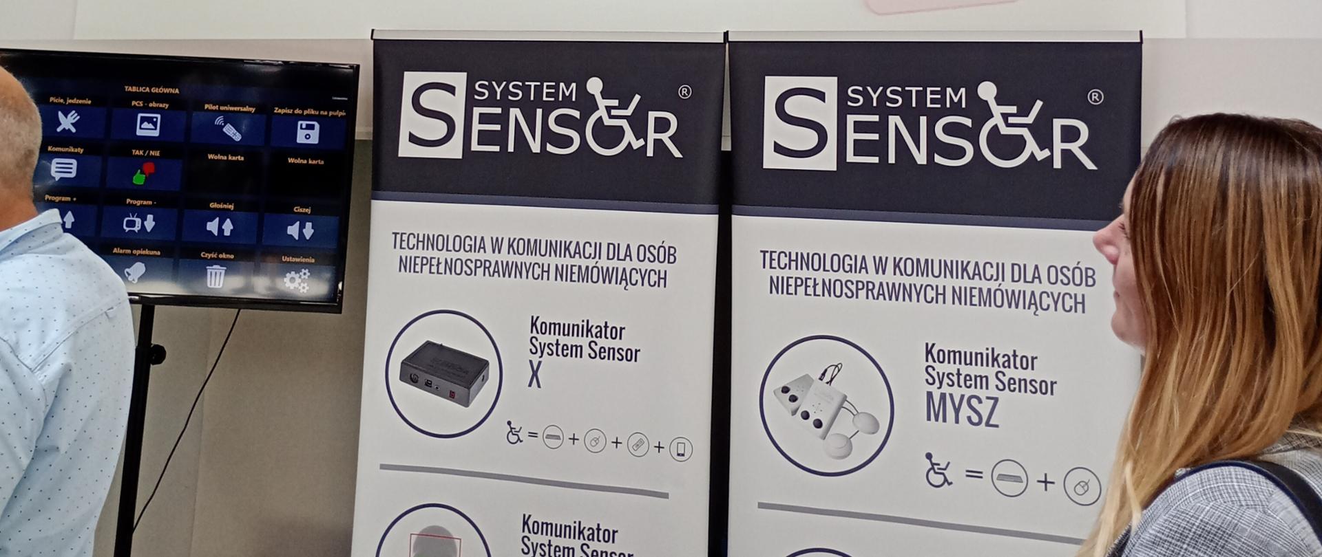 Pracownik WIORiN stojący przy tablicach informacyjnych.