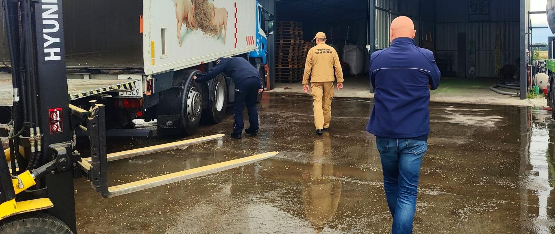 funkcjonariusze w trakcie kontroli sprzętu w gospodarstwie rolnym