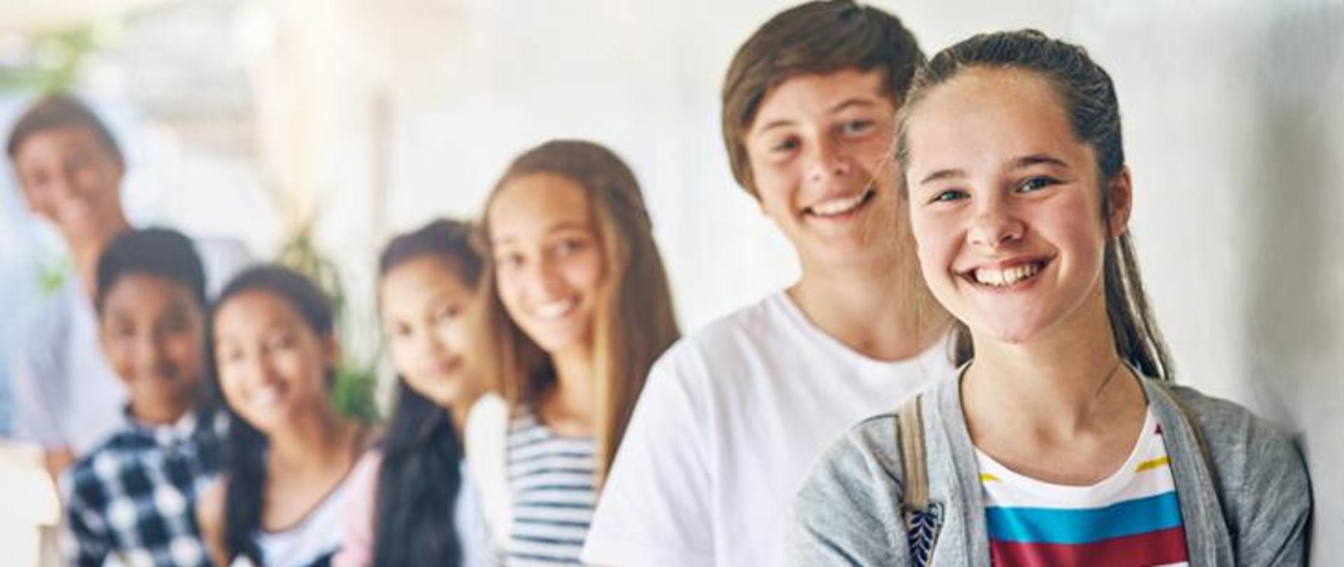 Nastolatek, przyjaciele i portret na terenie szkoły lub w kontekście rozwoju nauki, edukacji lub stypendium. Dziewczęta, chłopcy i twarze na korytarzu budynku z książkami do nauki lub razem, w grupie lub z uśmiechem.