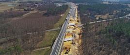 Budowa obiektów inżynierskich pod drogą. Widok z lotu ptaka. W bliższej perspektywie dwa obiekty i prace na nich wykonywane. W oddali widać kolejne obiekty pod drogą.