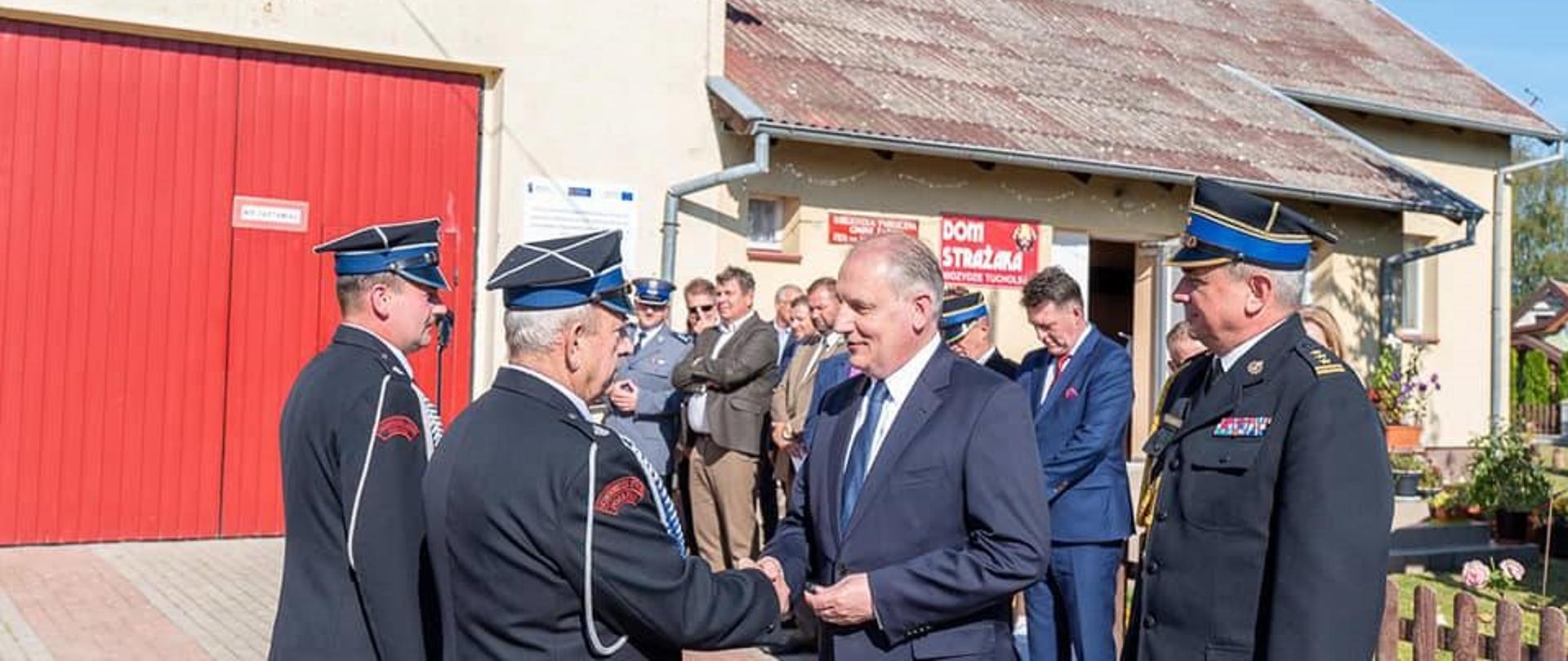 Wojewoda pomorski w obecności pomorskiego komendanta wojewódzkiego Państwowej Straży Pożarnej, wręcza kluczyki do nowego samochodu, gratulując dwóm przedstawicielom ochotniczej straży pożarnej. 