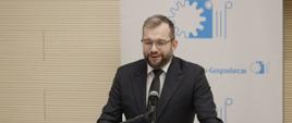 Minister funduszy i polityki regionalnej Grzegorz Puda na Forum Akademicko-Gospodarczym, minister stoi przy mikrofonie i przemawia