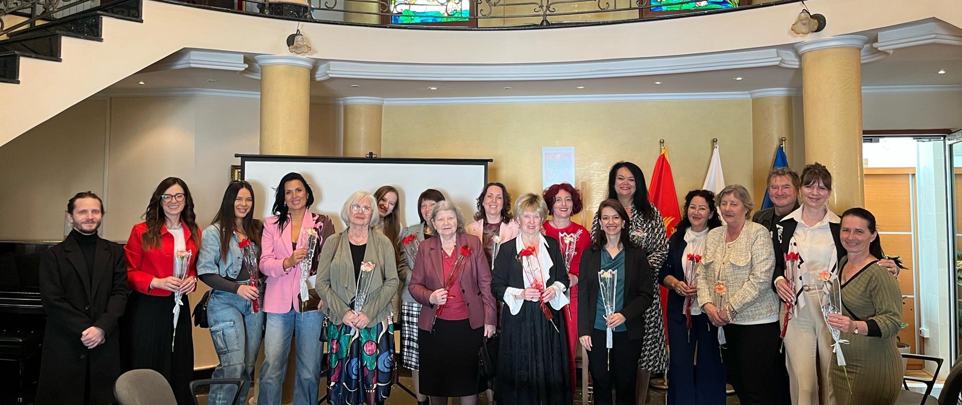 Članovi Udruženja Poljaka sa konzulkom, grupna fotografija, u ruci drže cvijeće, u pozadini zastave Crne Gore, Poljske i EU