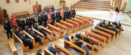 zdjęcie przedstawia uczestników uroczystości siedzących w ławkach podczas mszy w kościele