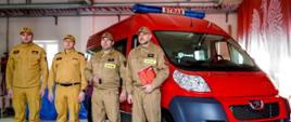 Na zdjęciu widać busa marki Peugeot Boxer przy którym stoi komendant powiatowy i zastępca oraz strażacy OSP