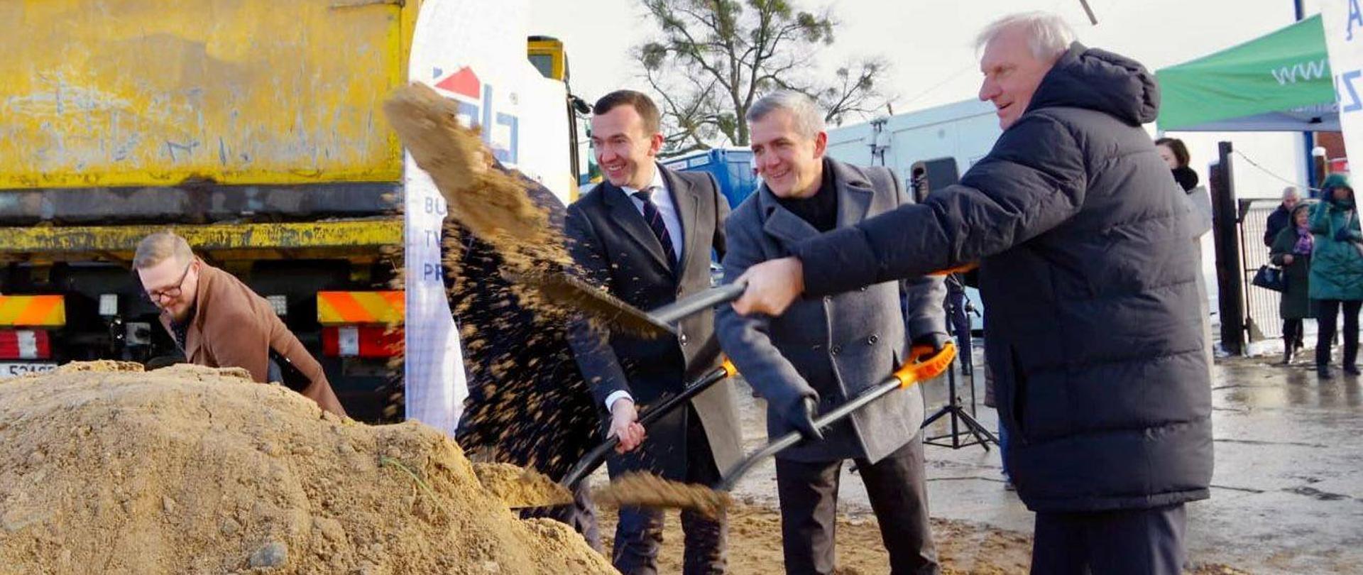 Mężczyźni kopią w piachu 