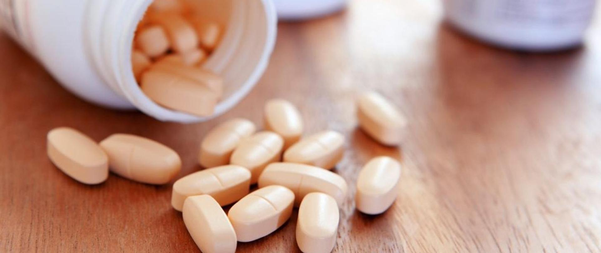 Na zdjęciu znajdują się rozsypane na stole tabletki