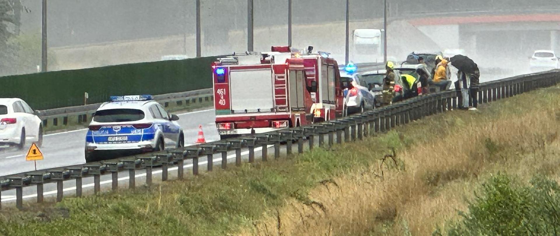 widoczne miejsce zdarzenia uszkodzone pojazdy oraz służby podczas działań.