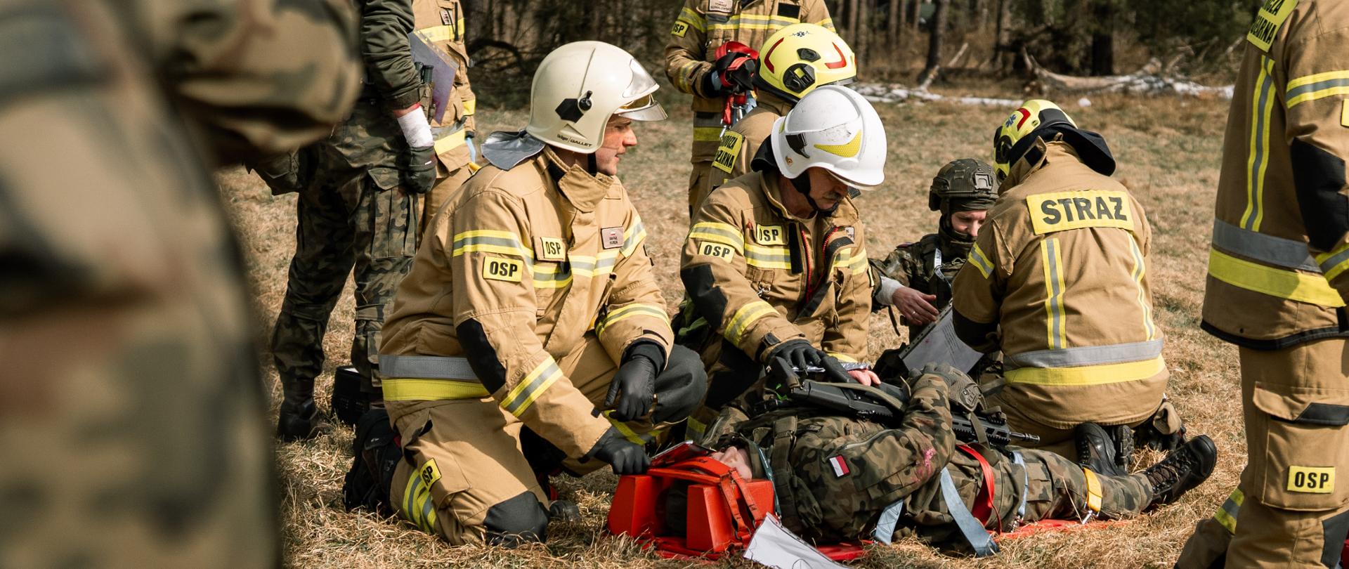Żołnierze i ratownik medyczny opatrują poszkodowanego.
