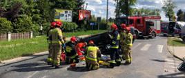 Ratownicy zabezpieczający miejsce zdarzenia i przekazujący poszkodowanego dla ratowników medycznych