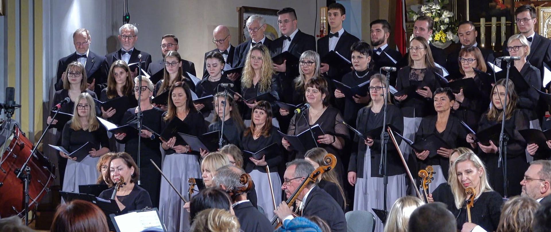 Zdjęcie przedstawia orkiestrę symfoniczną i chór podczas koncertu w Kościele.