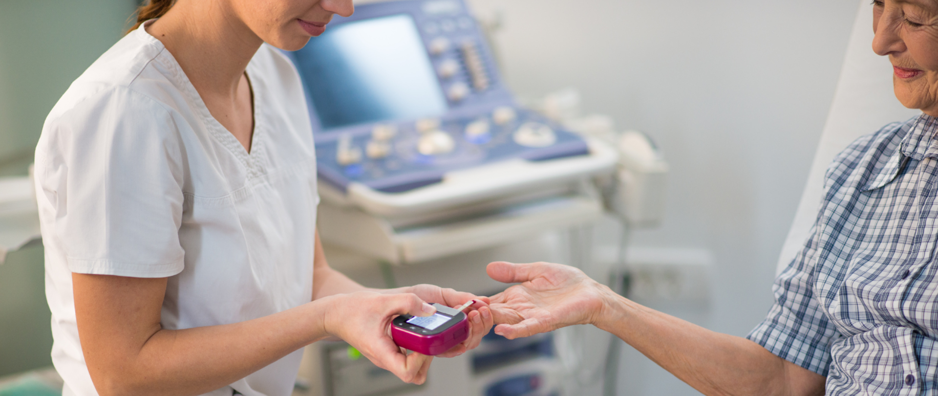 Pielęgniarka bada pacjentce poziom glukozy we krwi za pomocą elektronicznego glukometru