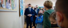 Premier, wicepremier oraz minister Janusz Cieszynski stoją wśród dzieci.