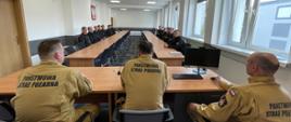 Strażacy podczas omówienia i zakończenia ćwiczeń wysokościowych w sali szkoleniowej. 
