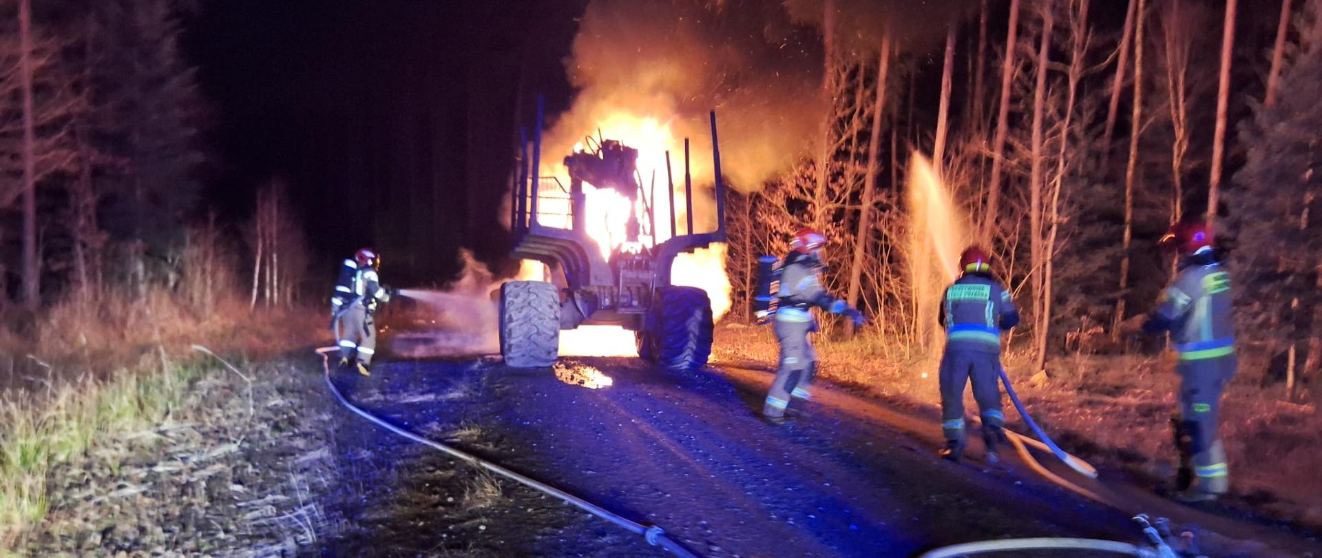 Maszyna w ogniu strażacy podający prądy wody na pożar. pora nocna