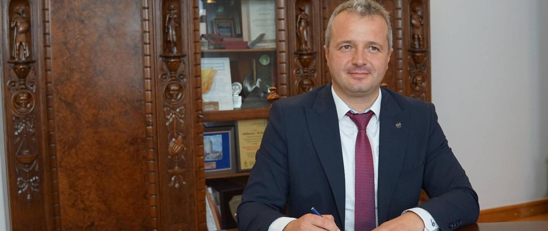 
Mężczyzna w garniturze podpisuje dokumenty
