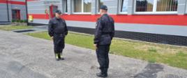 dwóch strażaków stoi na przeciwko siebie