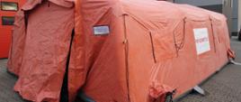 Pomarańczowy pneumatyczny namiot strażacki z napisem WFOŚiGW w Poznaniu i PSP SZAMOTUŁY na białym tle.