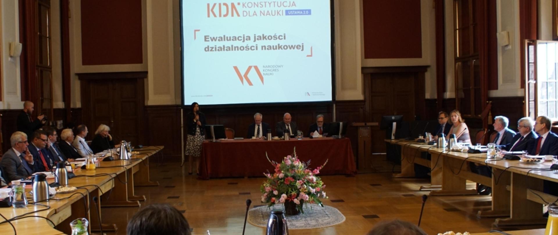 Na zdjęciu widać wicepremiera Gowina i inne osoby, siedzące przy stole podczas spotkania dot. nowych zasad ewaluacji