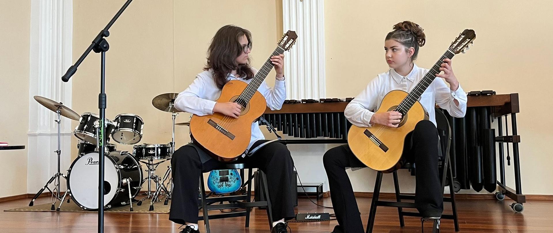 Wykonawcy przy instrumentach na scenie w sali koncertowej podczas Uroczystego Koncertu Absolwentów