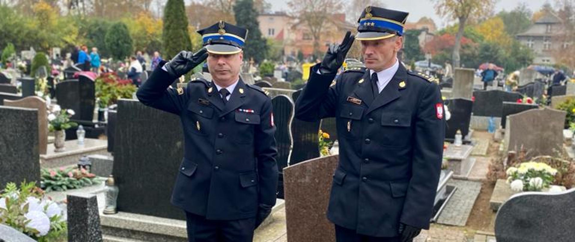 Komendant powiatowy, zastępca komendanta w trakcie oddawania honoru przy grobie zasłużonego strażaka.