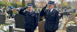 Komendant powiatowy, zastępca komendanta w trakcie oddawania honoru przy grobie zasłużonego strażaka.