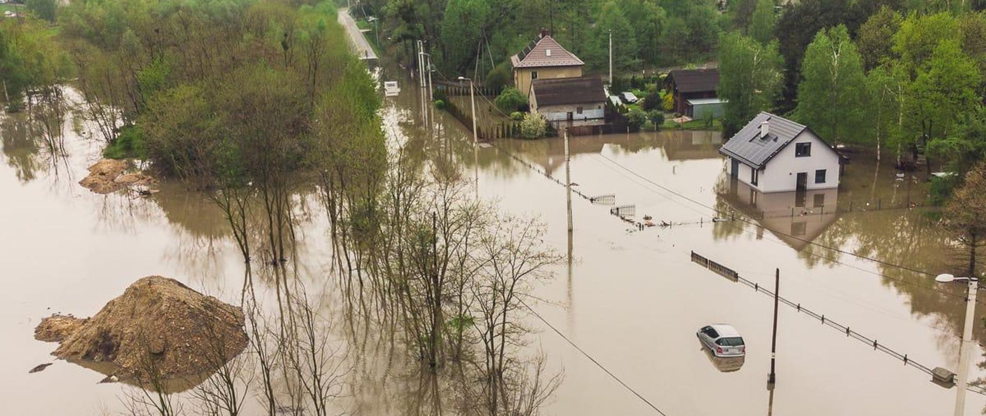 Na zdjęciu zlana jezdnia oraz domy i posesje w wyniku nawałnicy