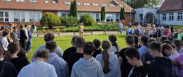Funkcjonariusz PSP podczas omawiania przebiegu ewakuacji oraz pogadanki dla uczniów i kadry szkoły podstawowej.