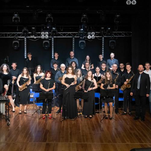 Jubileusz 10-lecia pracy artystycznej Big Bandu PSM w Głubczycach. Zdjęcie Big Bandu pozującego na scenie MOK w Głubczycach.