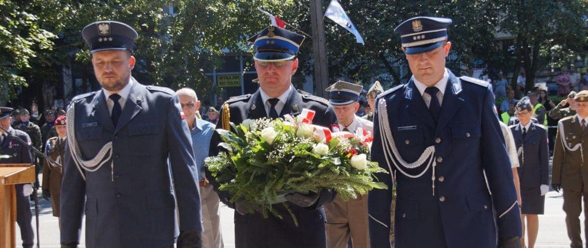 Zastępca Komendanta Powiatowego PSP w Grójcu bryg. Krzysztof Kędziera składa kwiaty w Święto Wojska Polskiego z przedstawicielami służb mundurowych