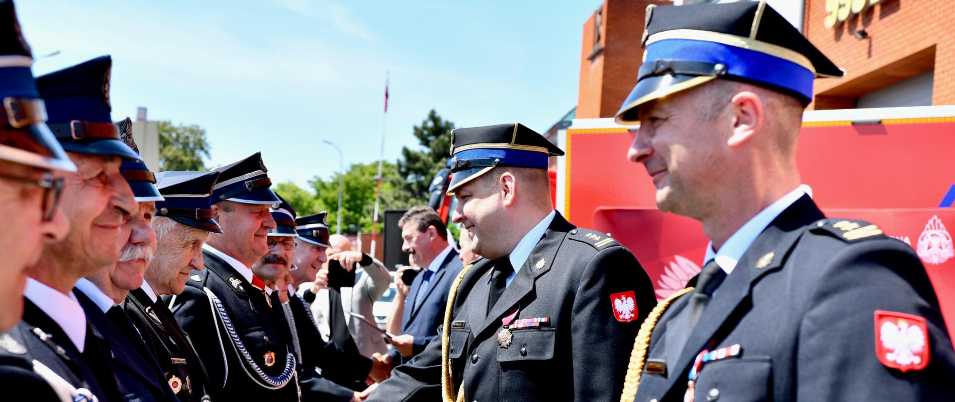 strażak ściska dłoń drugiemu strażakowi
