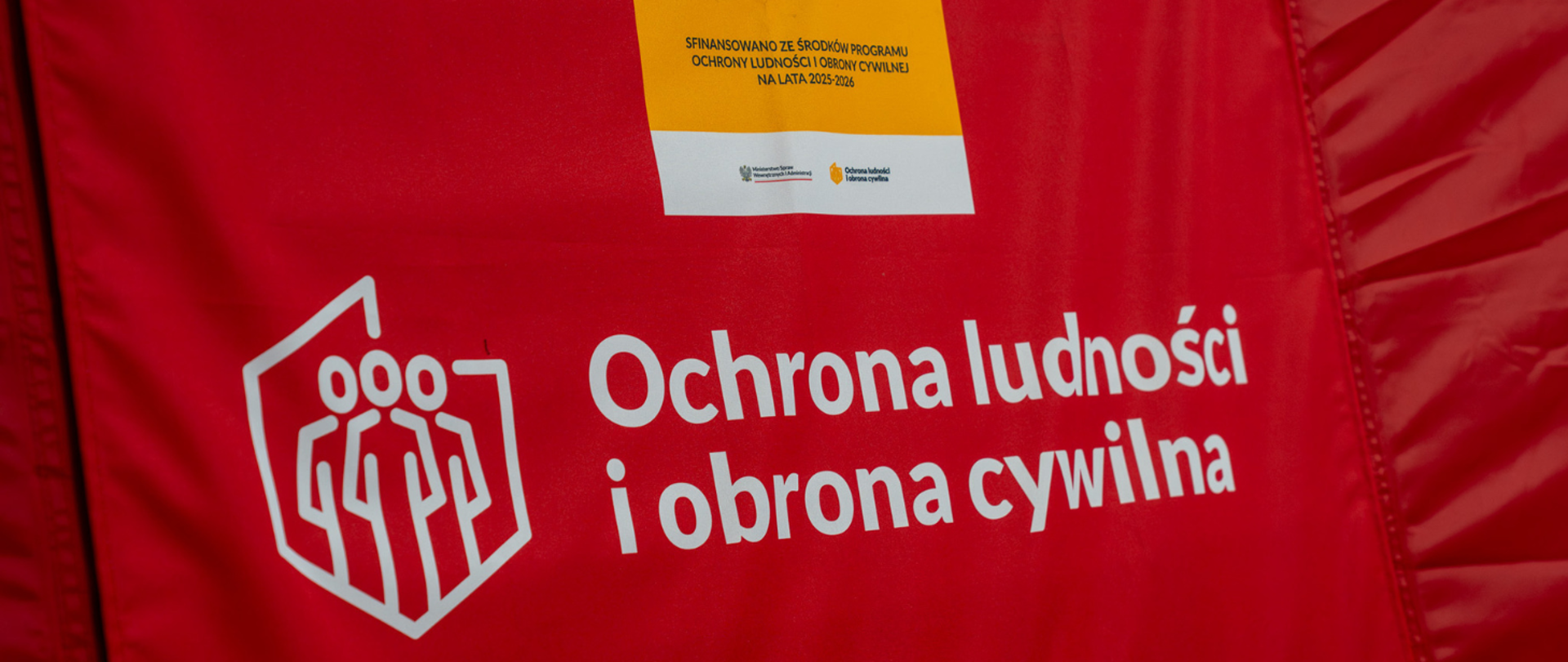 Zdjęcie przedstawia sprzęt z logo związane z OLIOC (Ochrona Ludności i Obrony Cywilnej)