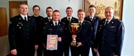 Na zdjęciu od lewej stoją kpt. Tomasz Janus wydział kontrolno rozpoznawczy, następnie z tyłu sekc. Patryk Perlejewski JRG 11, mł. bryg. Łukasz Kaczmarczyk, z Przodu z dyplomem kierownik drużyny bryg. Artur Wójcik, za nim z tyłu st. kpt. Michał Klaus Wydział Operacyjny, z przodu z pucharem st. kpt. Przemysław Girgiel JRG 16 z drugim rzędzie asp. Łukasz Grabowski JRG 16, pierwszy od prawej stoi Komendant Miejski PSP m. st. Warszawy bryg. Roman Krzywiec. 