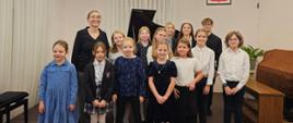 Zdjęcie przedstawia uczestników koncertu "Fortepian z klasą" wraz z Panią Angeliką Strzygocką