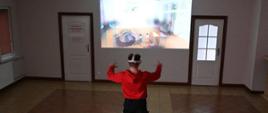 Na zdjęciu znajduje się uczeń szkoły średniej ubrany w okulary VR podczas symulacji zachowania w przypadku występowania tlenku węgla.