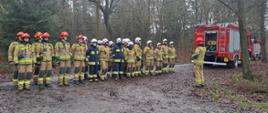 Zdjęcie przedstawia strażaków PSP i OSP podczas odprawy przed ćwiczeniami gaszenia pożaru lasu.