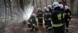 Druhowie OSP ćwiczący operowanie prądami gaśniczymi.