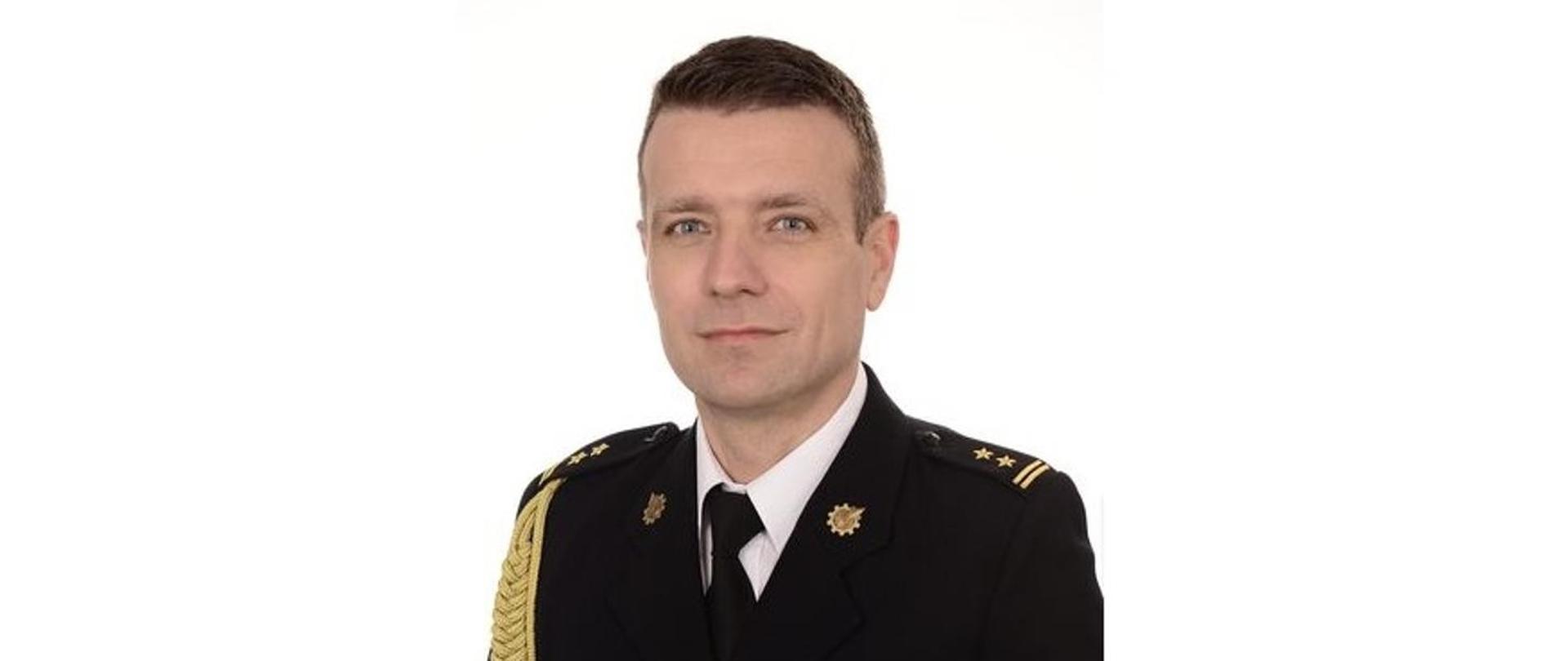 Zdjęcie portretowe Komendanta Powiatowego PSP na jasnym tle w mundurze galowym