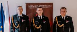 Trzech funkcjonariuszy Państwowej Straży Pożarnej podczas powierzania pełnienia obowiązków zastępcy komendanta powiatowego.