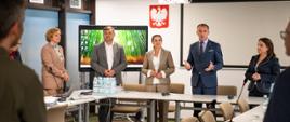 pięć osób pod godłem Polski