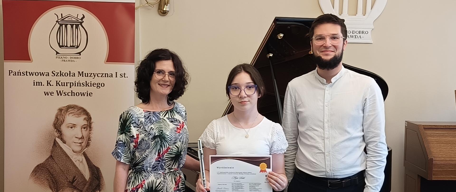 Uczennica w towarzystwie nauczycieli.