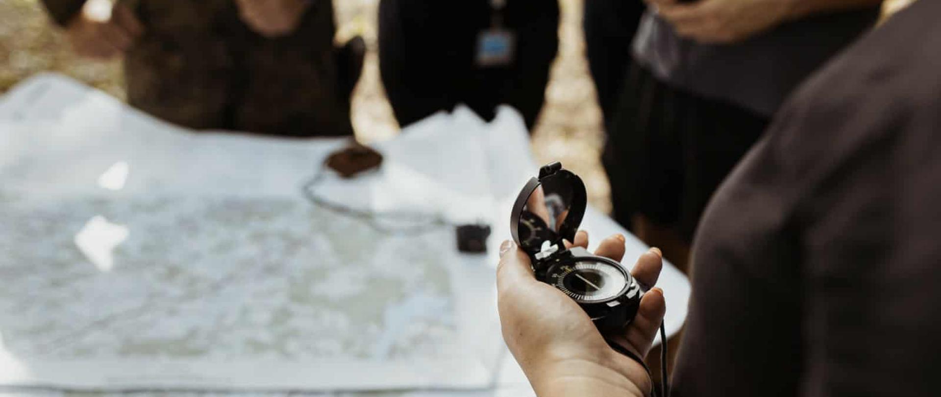 Zdjęcie przedstawia dłoń trzymającą kompas