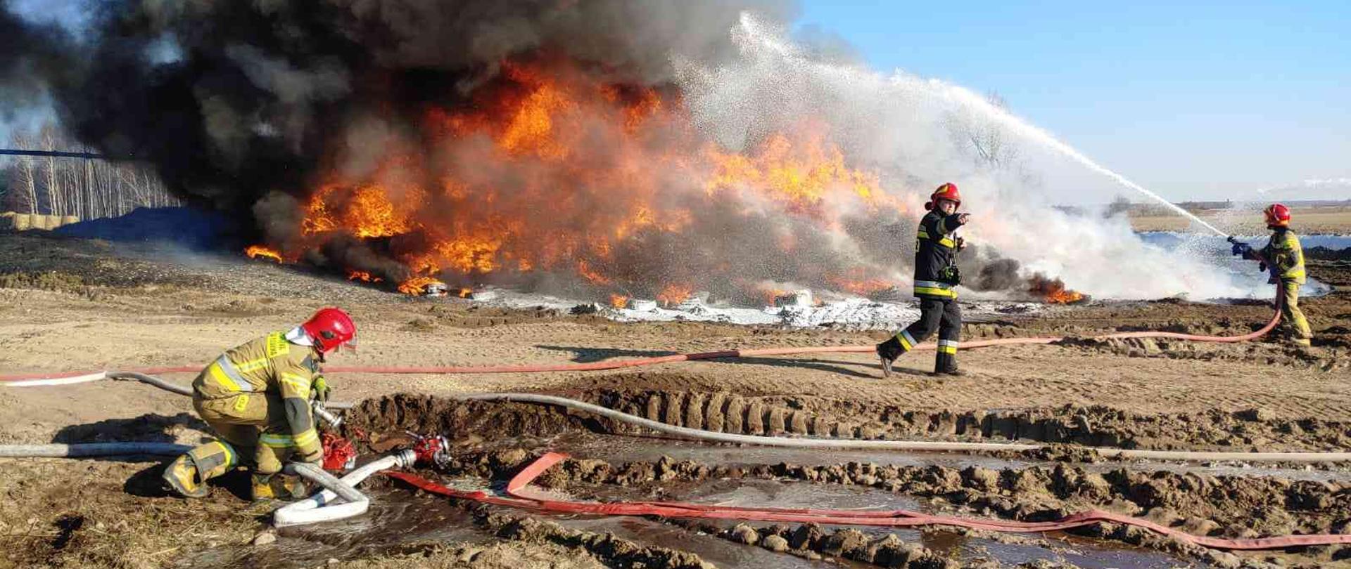 Strażacy gaszący palące się opony.