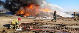 Strażacy gaszący palące się opony.