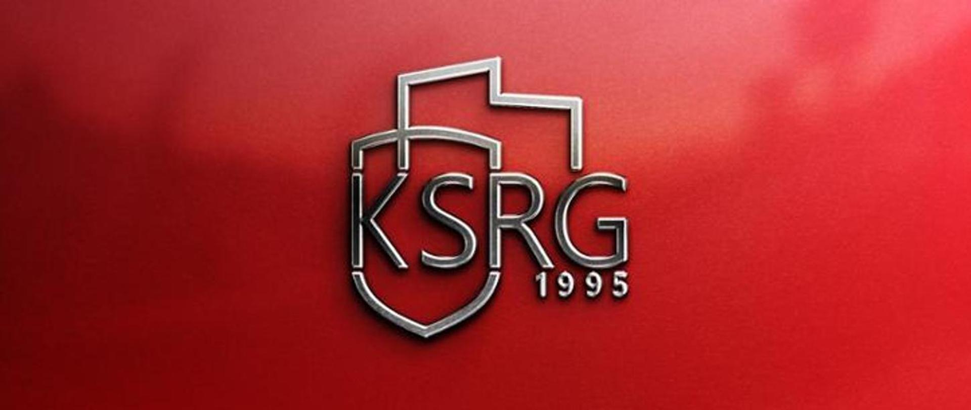Na czerwonym tle napis KSRG i pod nim rok 1995