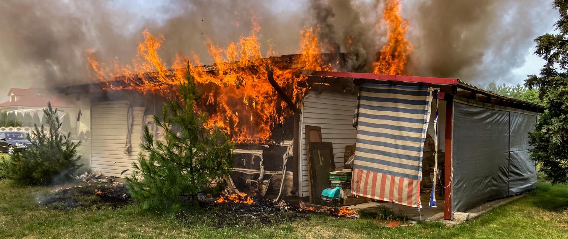 Zdjęcie przedstawia domek letniskowy objęty ogniem